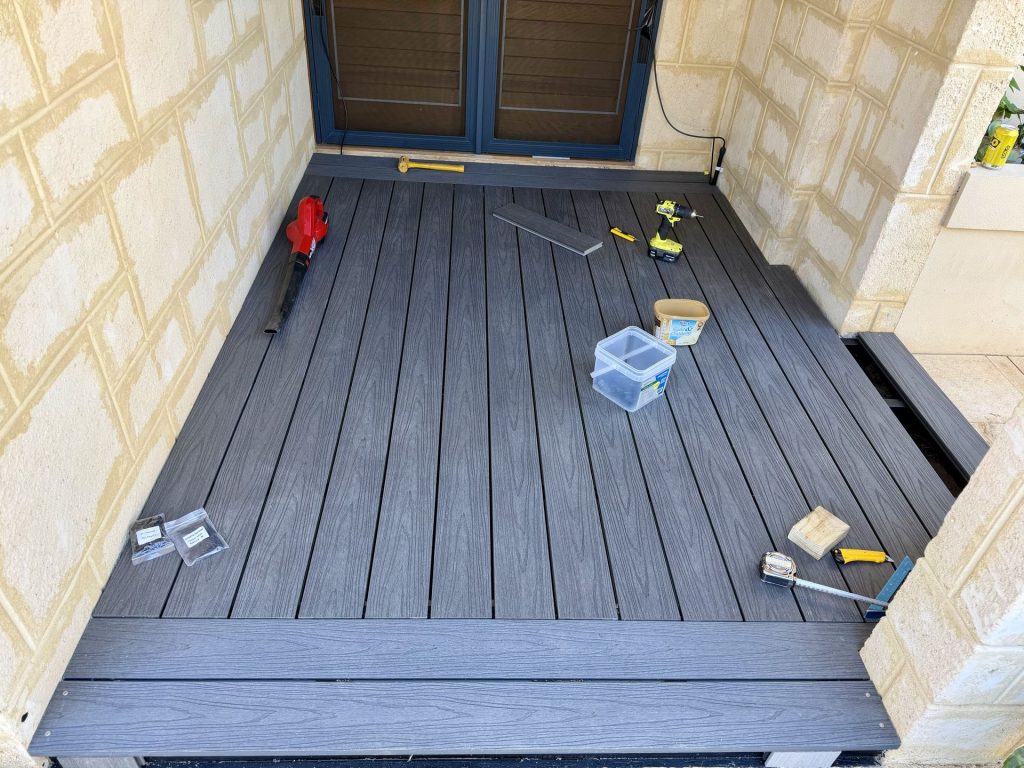 Charcoal composite deck landing at French doors with a fascia board step