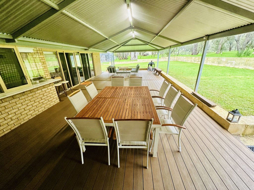 Composite alfresco dining deck under a gable patio on an acreage property