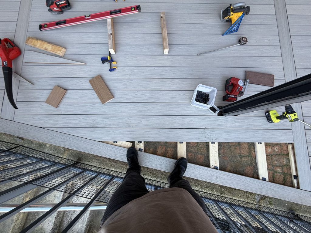 Composite deck boards fixed with hidden fastener clips over pine joists during install