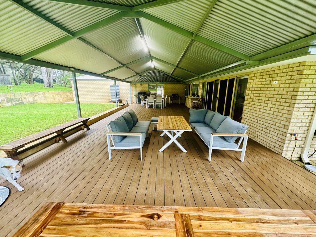 Composite deck under a gable patio set up for outdoor living