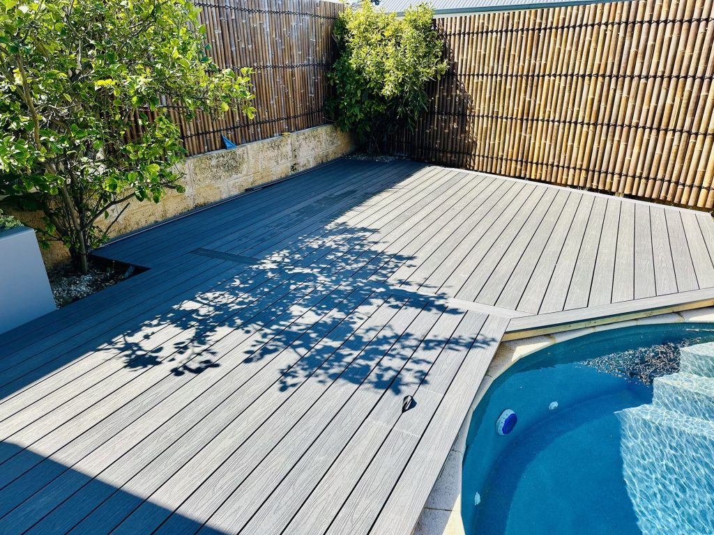 Composite pool decking scribed to the pool coping with bamboo screening behind