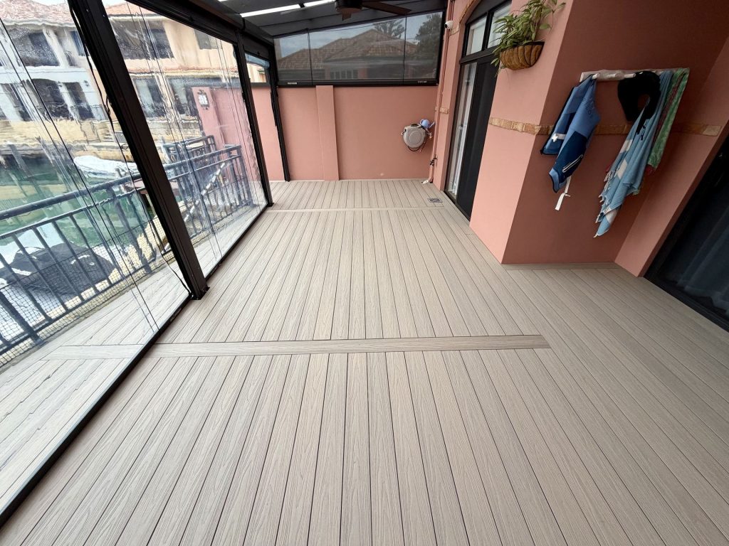 Light grey composite deck in an enclosed alfresco with cafe blinds overlooking the canal